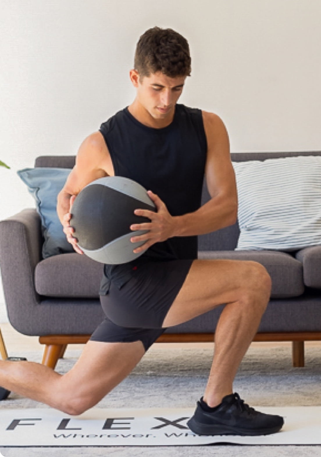 Young man twists and kneels with medicine ball