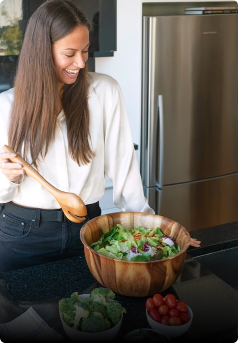 Health conscious woman preparing salad in a kitchen